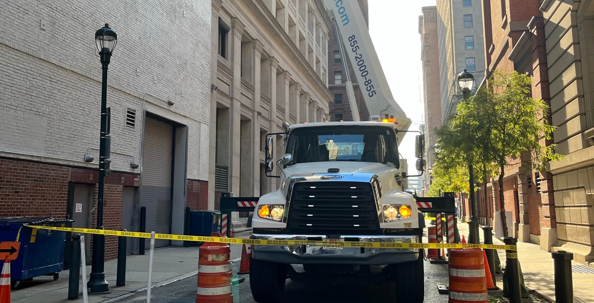 Boom lift set up in a narrow service street for facade repairs